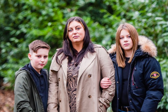 Stacy with her son and daughter looking into the camera