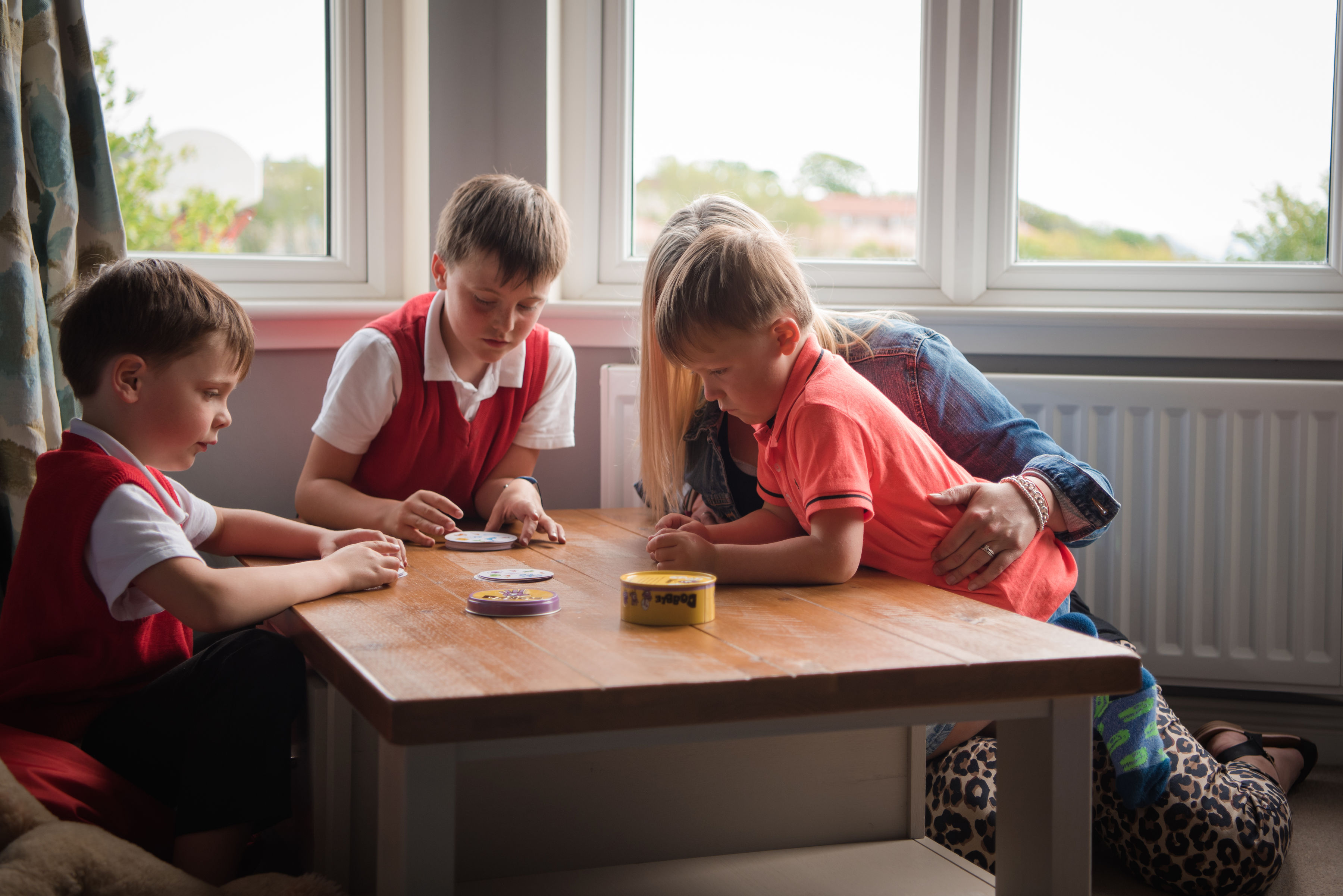 Kelly and the three boys playing at the table