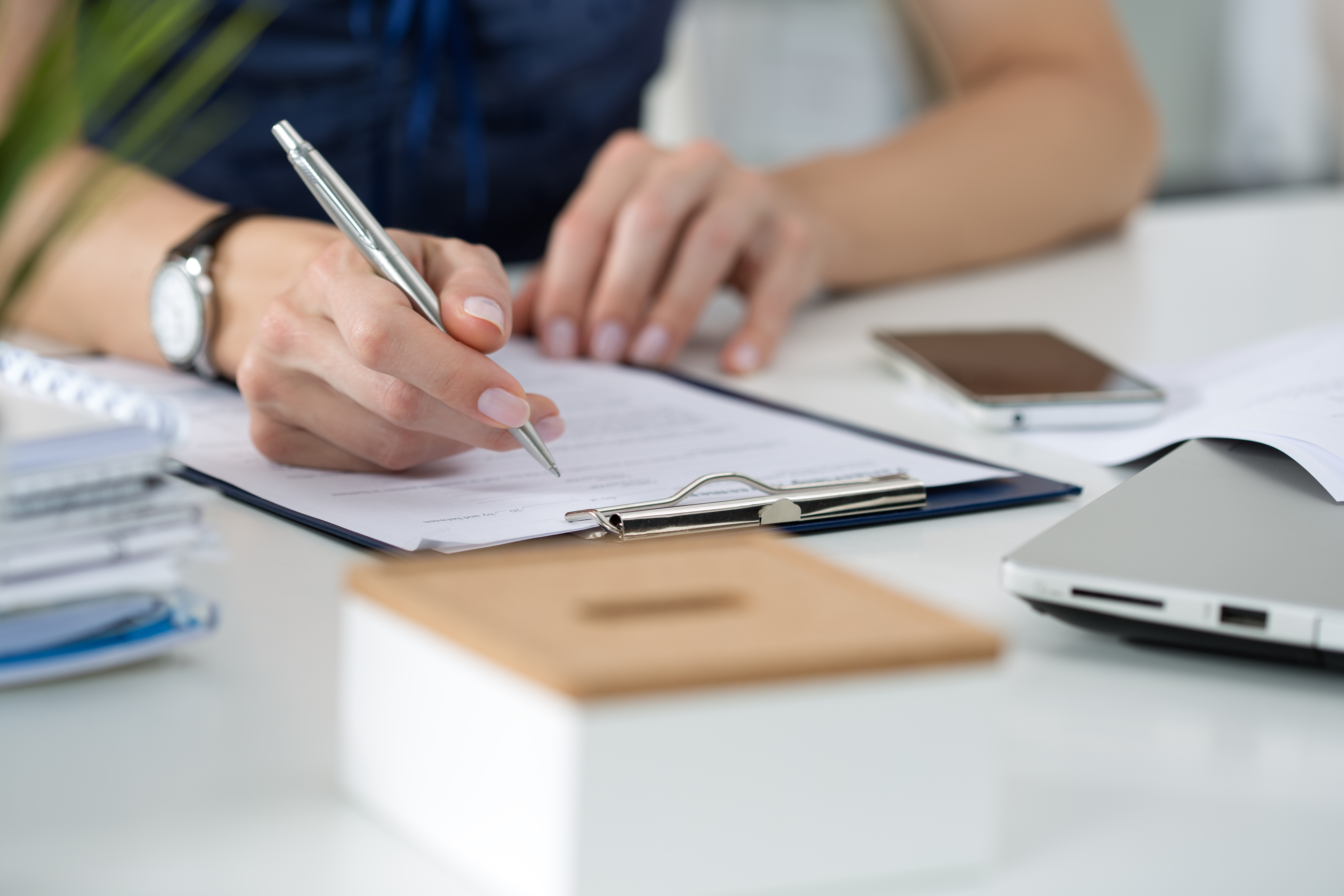 Woman writing on clipboard