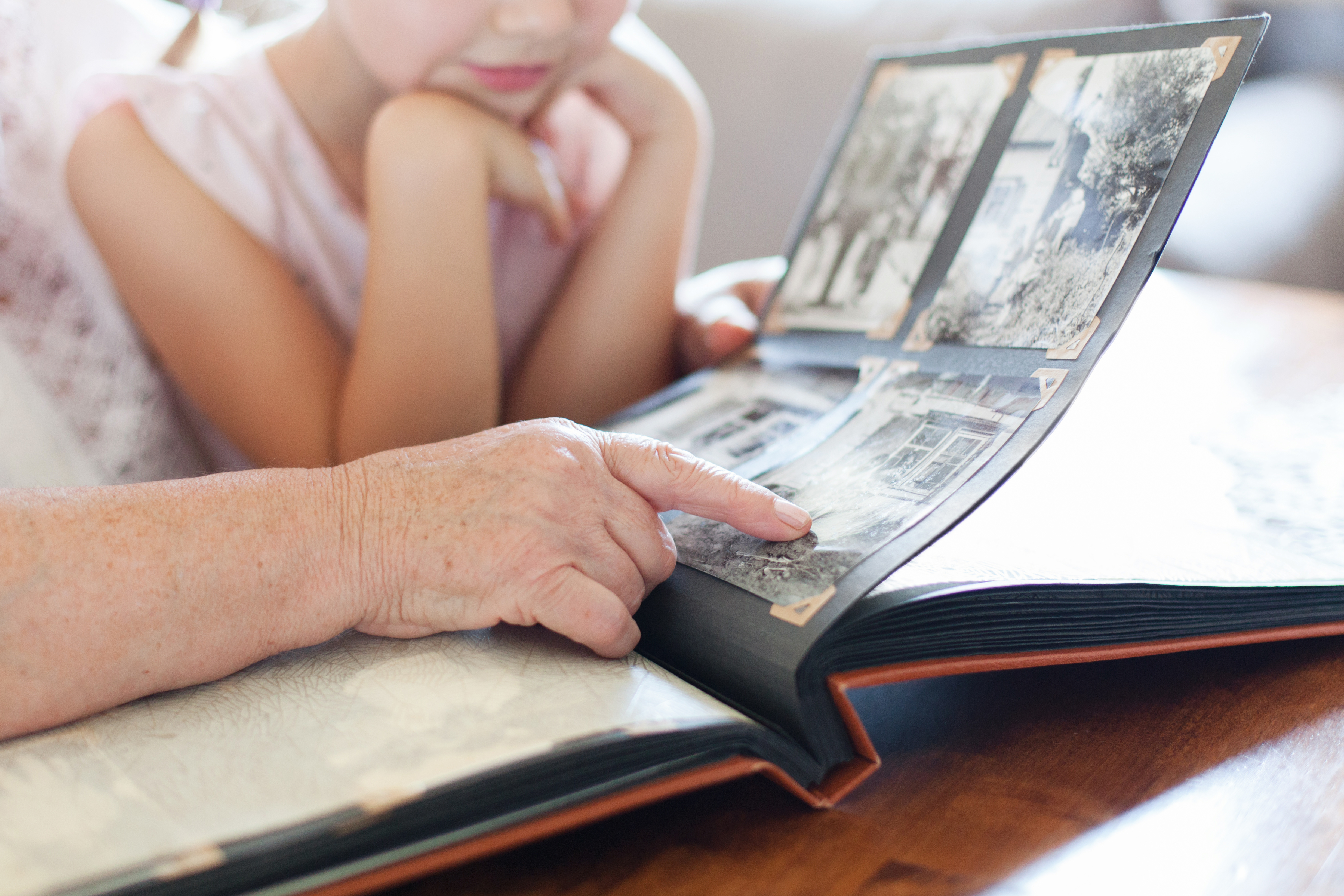 Grandmother and granddaughter looking through photo album