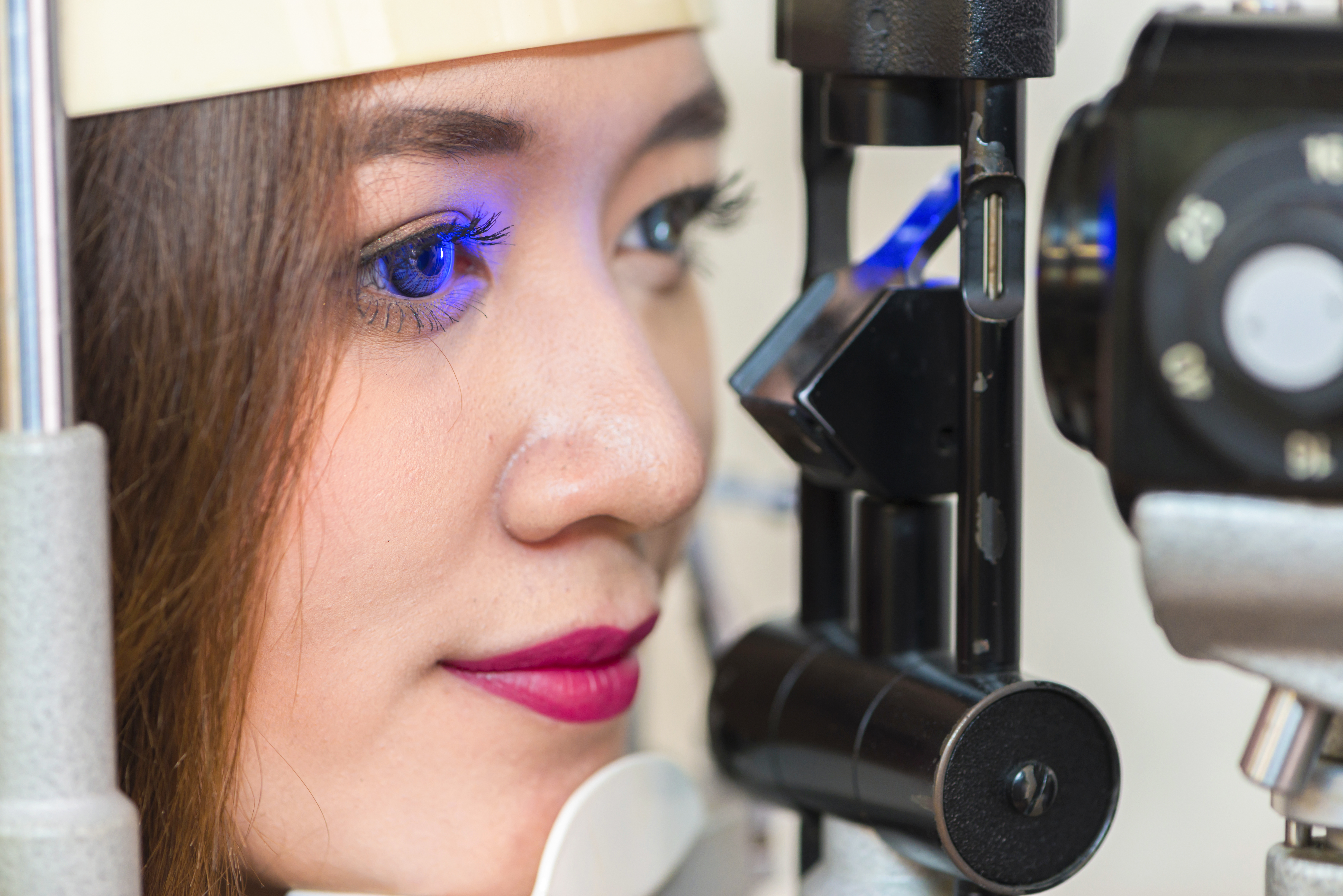 Woman having eye test with blue light.