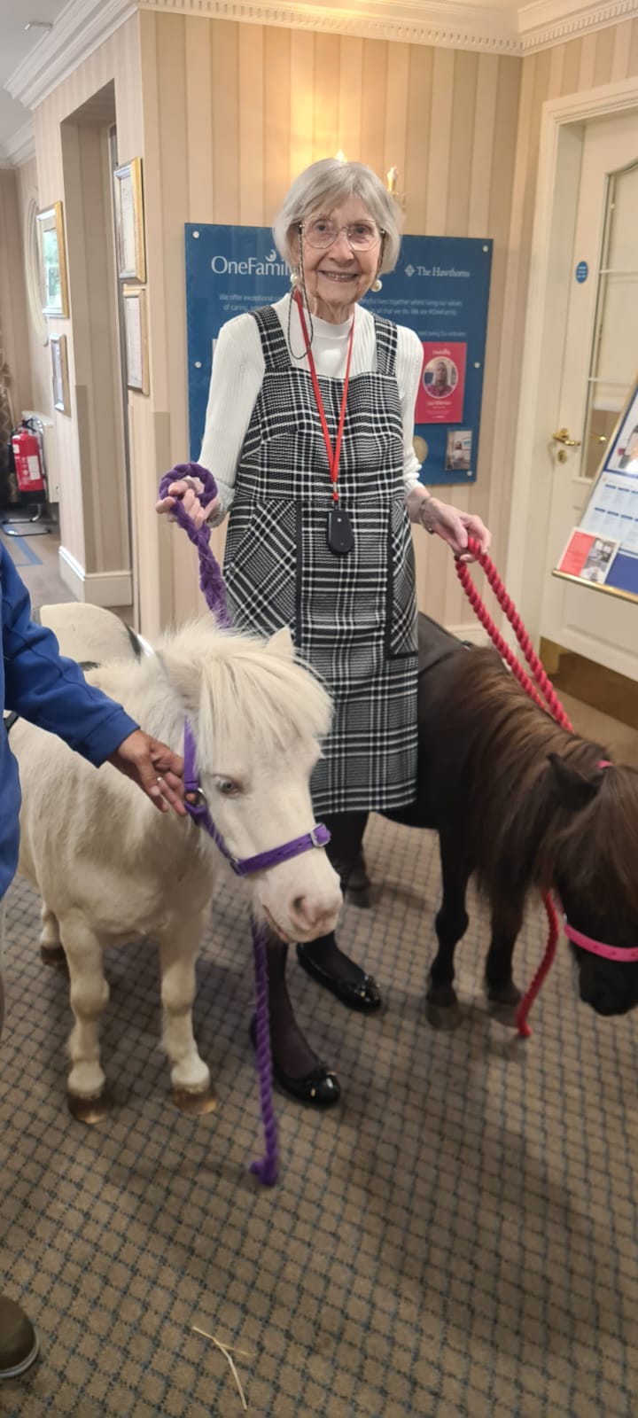 Rita, a white woman in her 80s with short grey hair smiling to camera