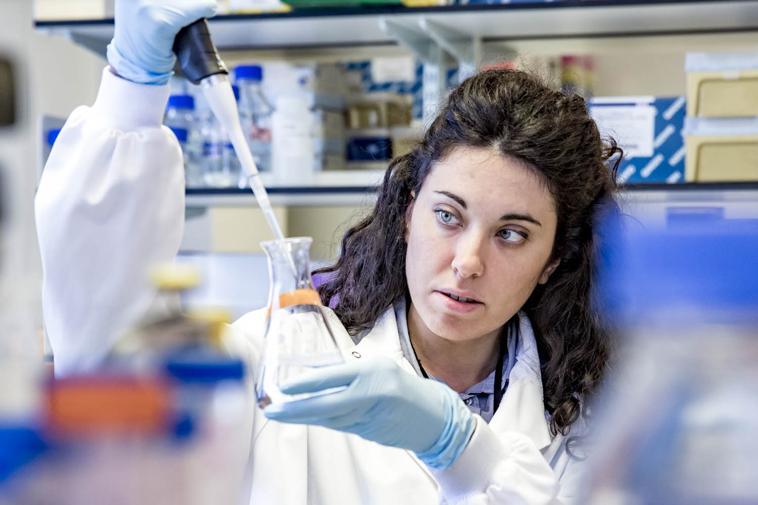 Researcher in laboratory with beaker 