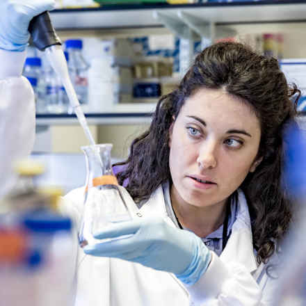 Researcher in laboratory with beaker 