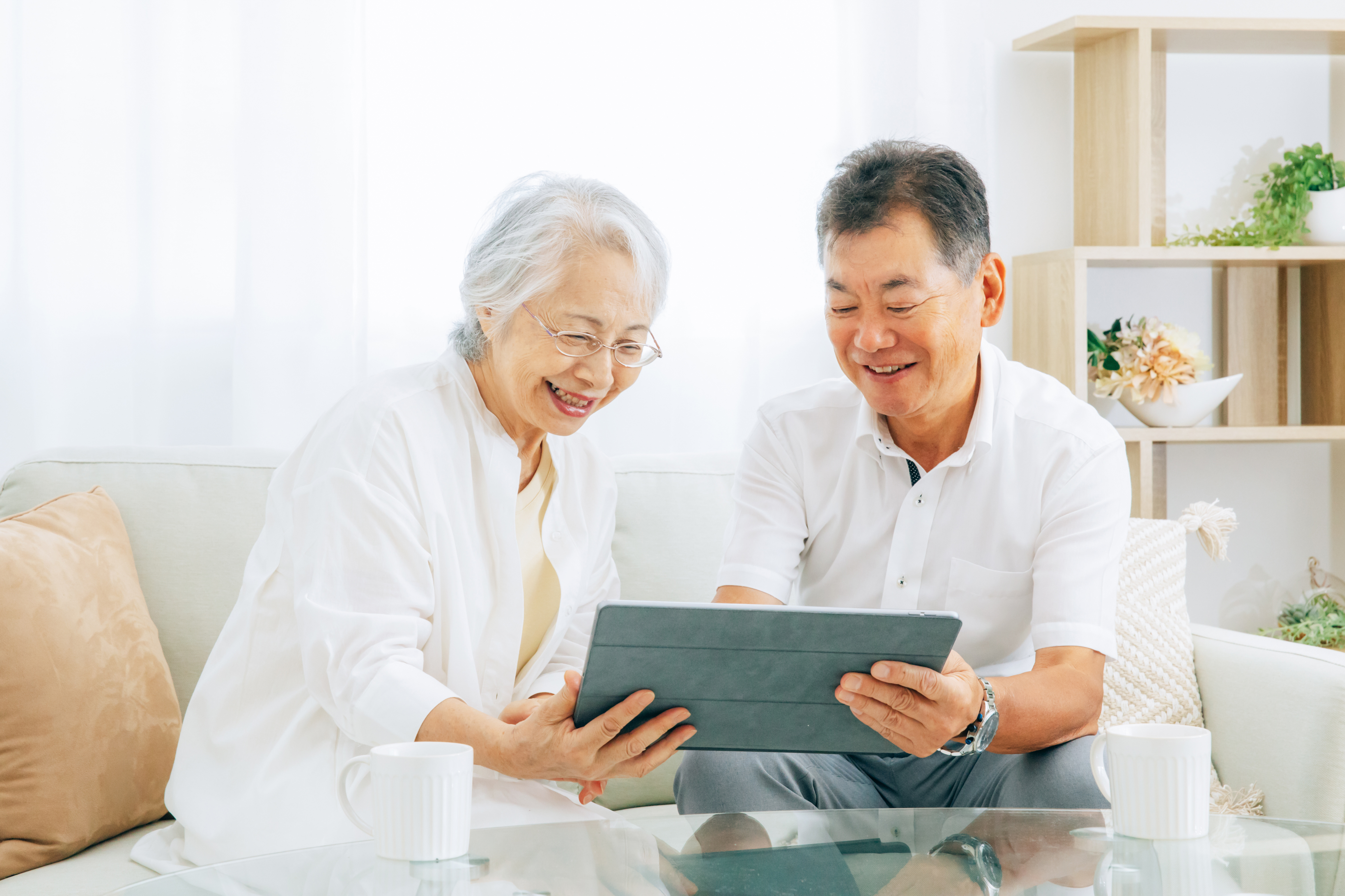 Male and female using tablet smiling