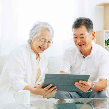 Male and female using tablet smiling