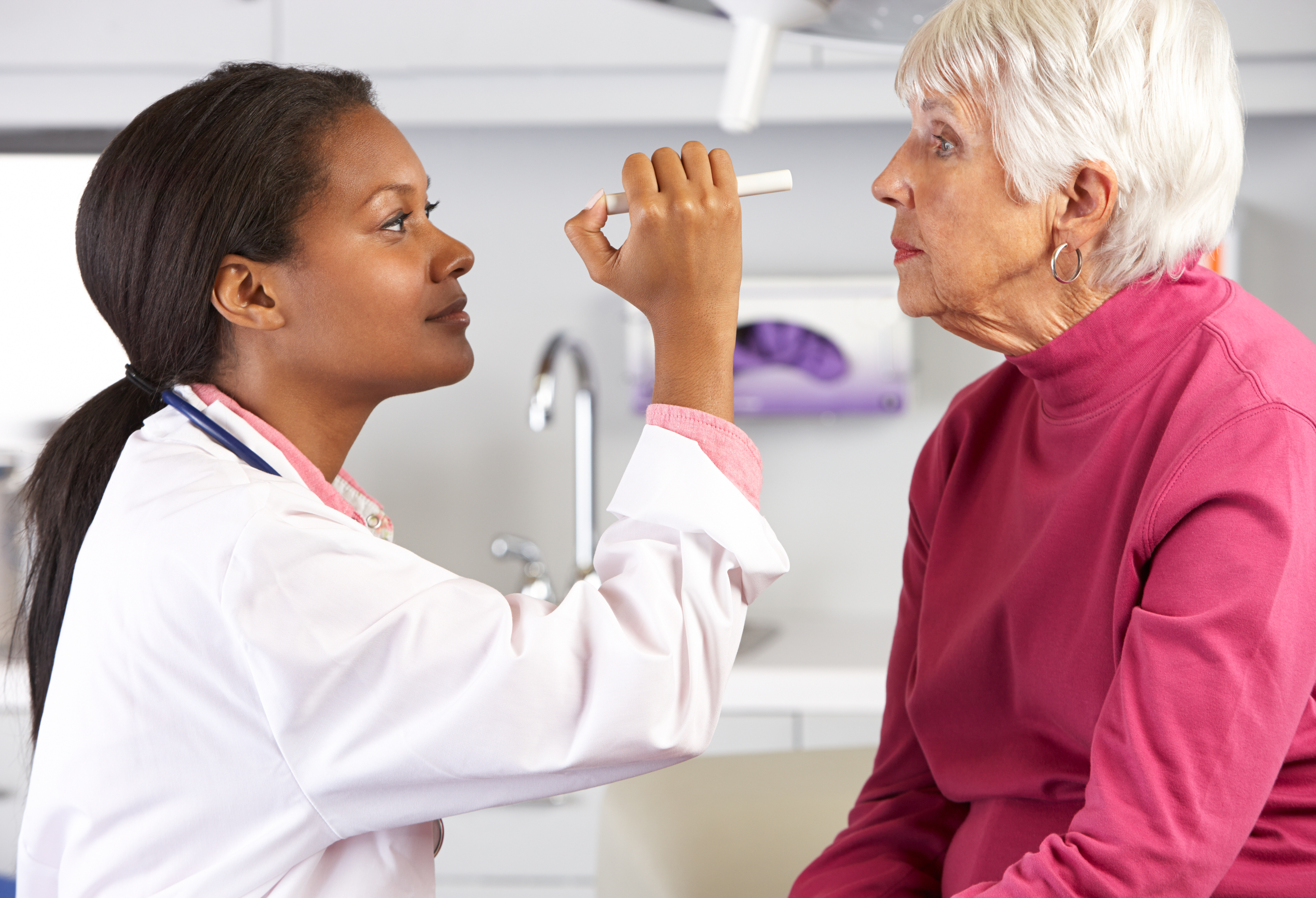 Nurse Looks Into Eyes Of Elderly Patient