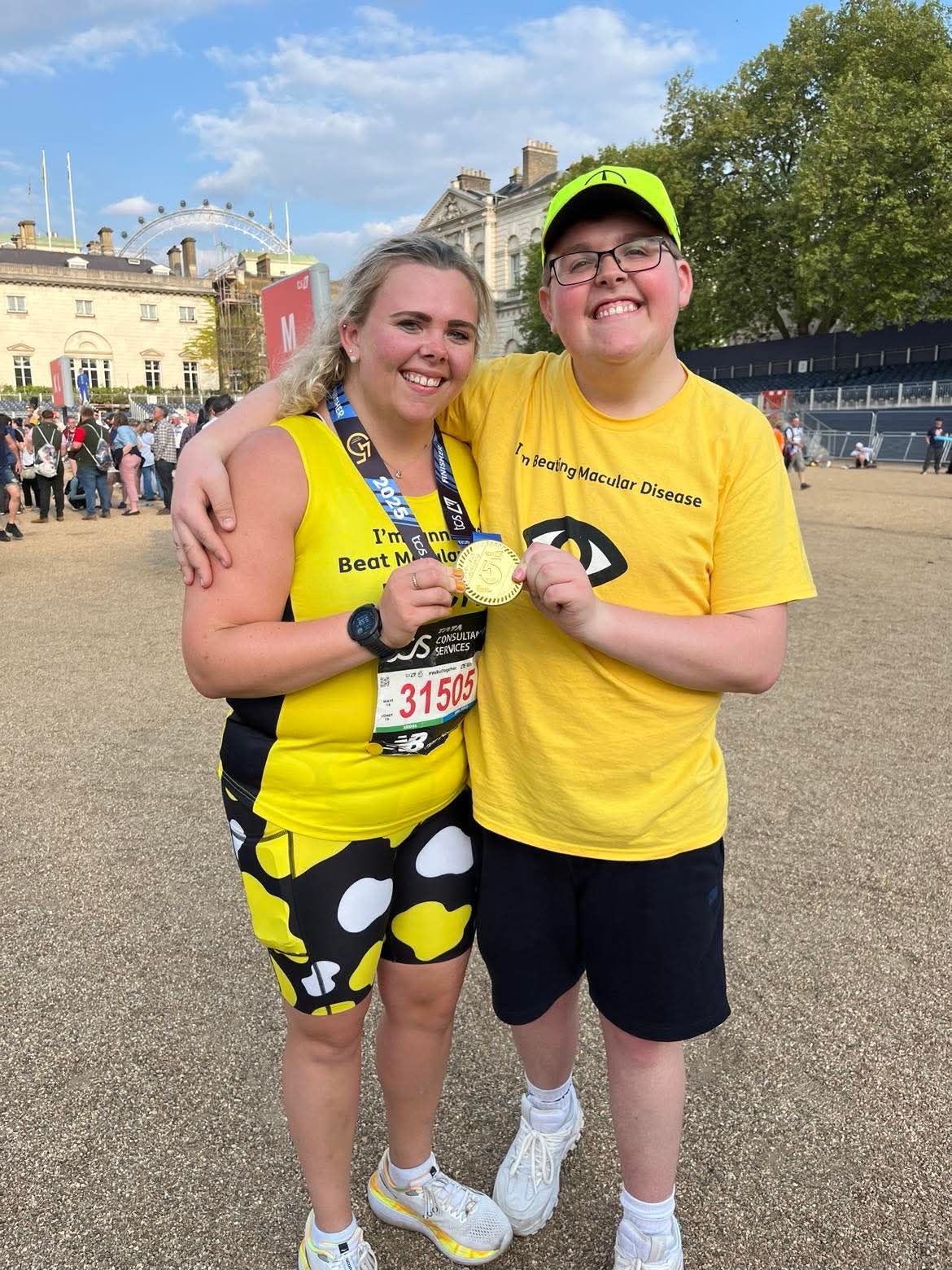 Becky and Richard with their arms around each other and smiling as they hold up Becky's London Marathon medal.