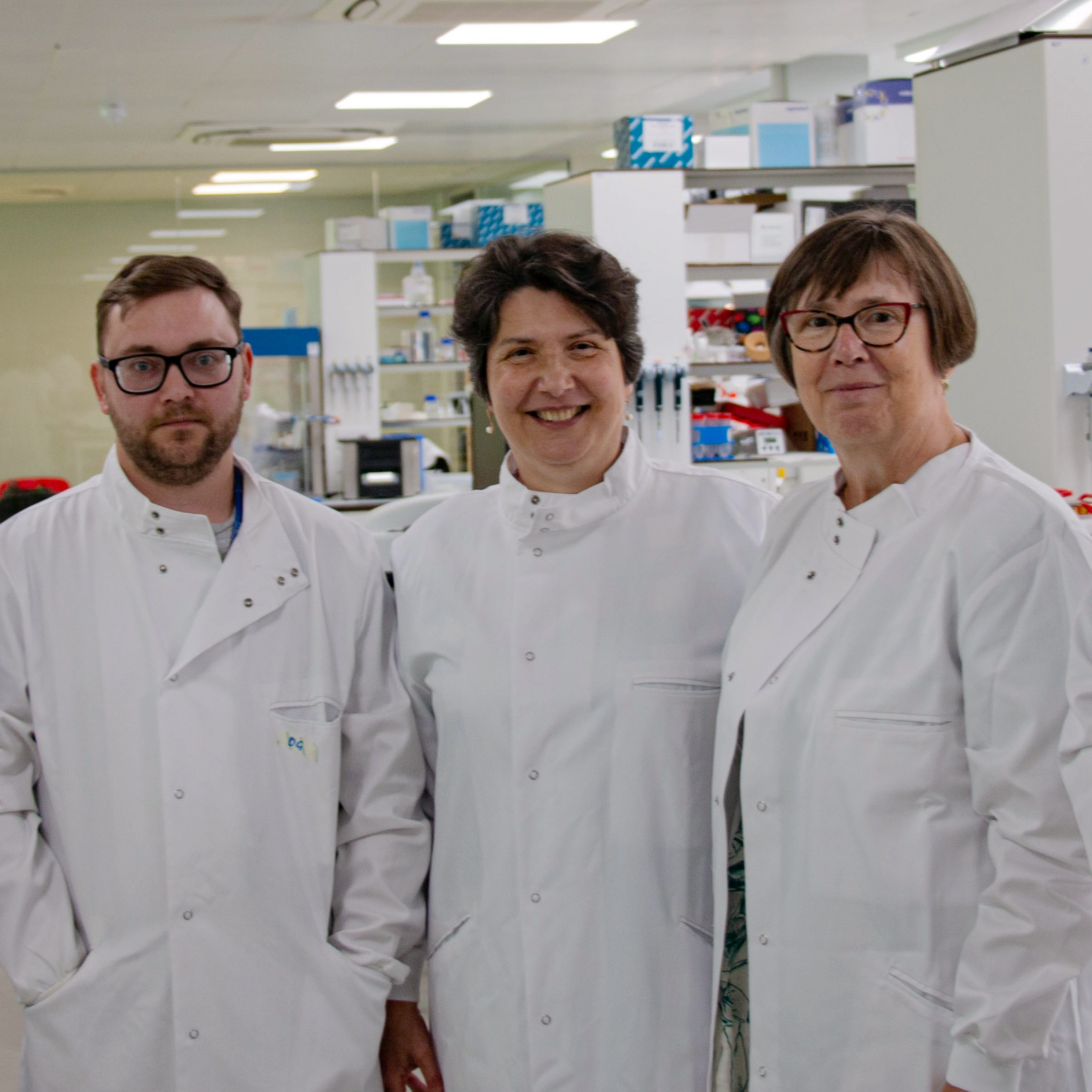 three scientists in white coats