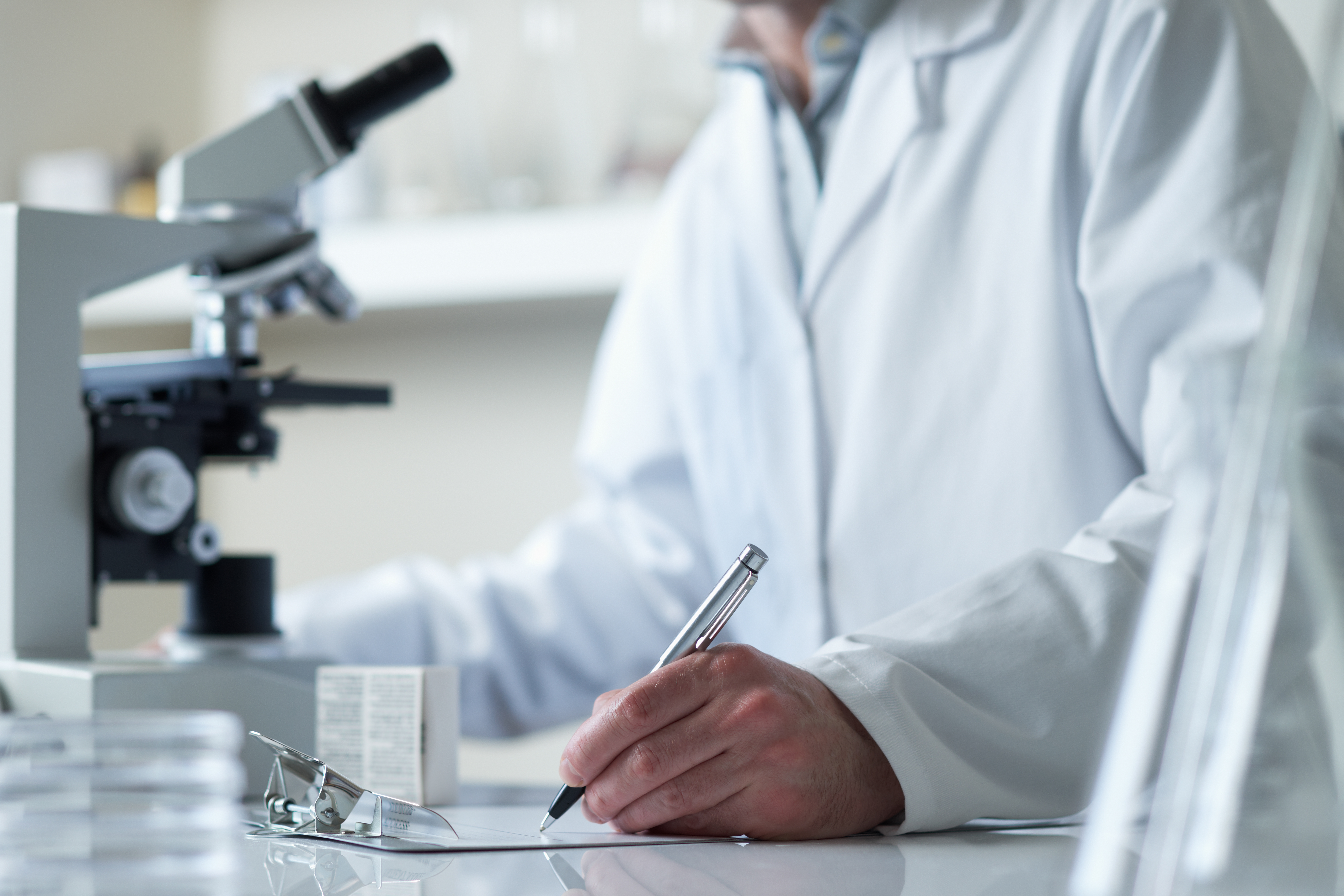 Scientist writing on a pad