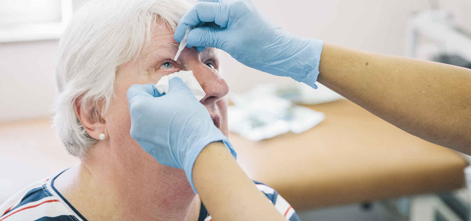 eye drops administered to senior woman