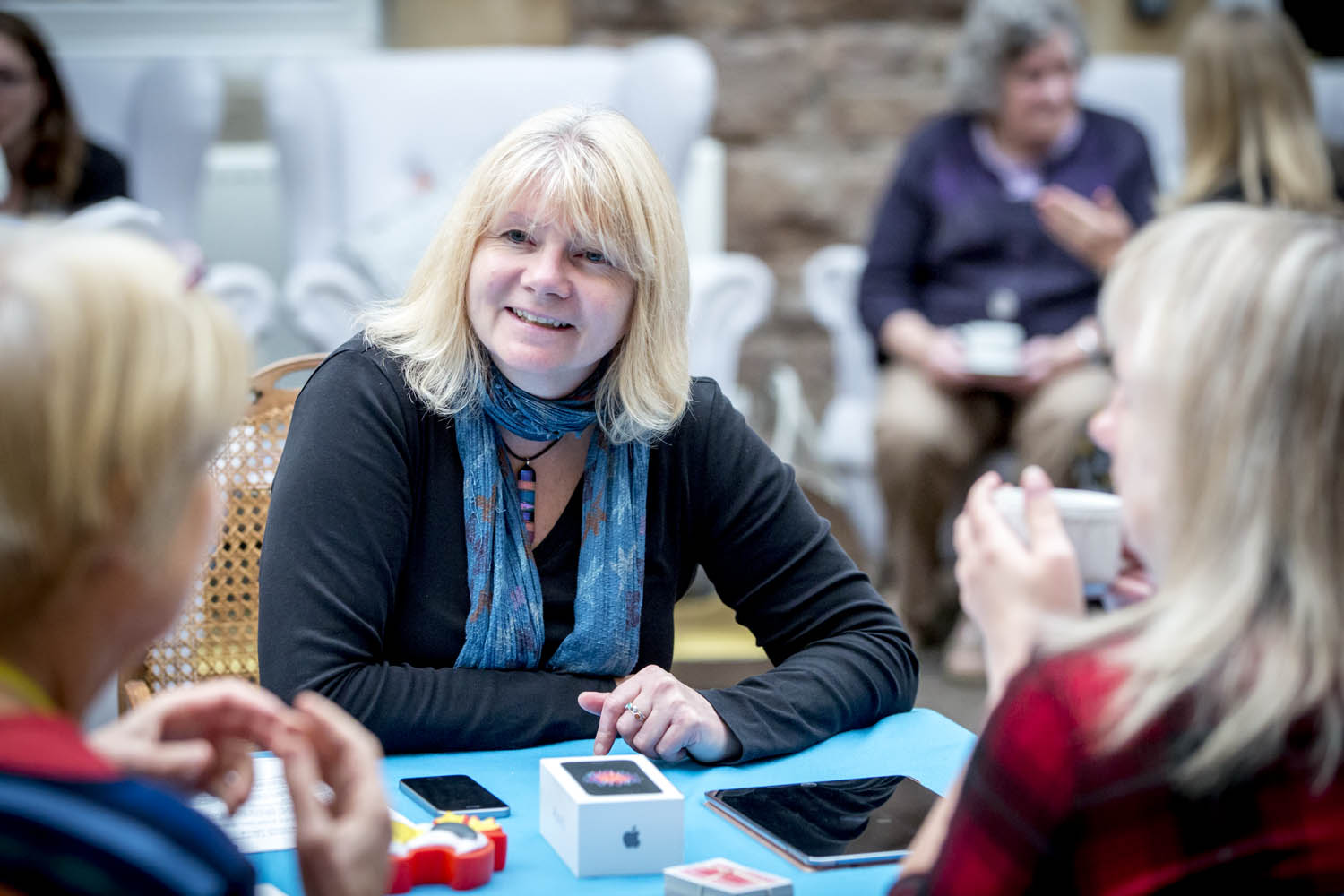 Group around table smiling with tablets