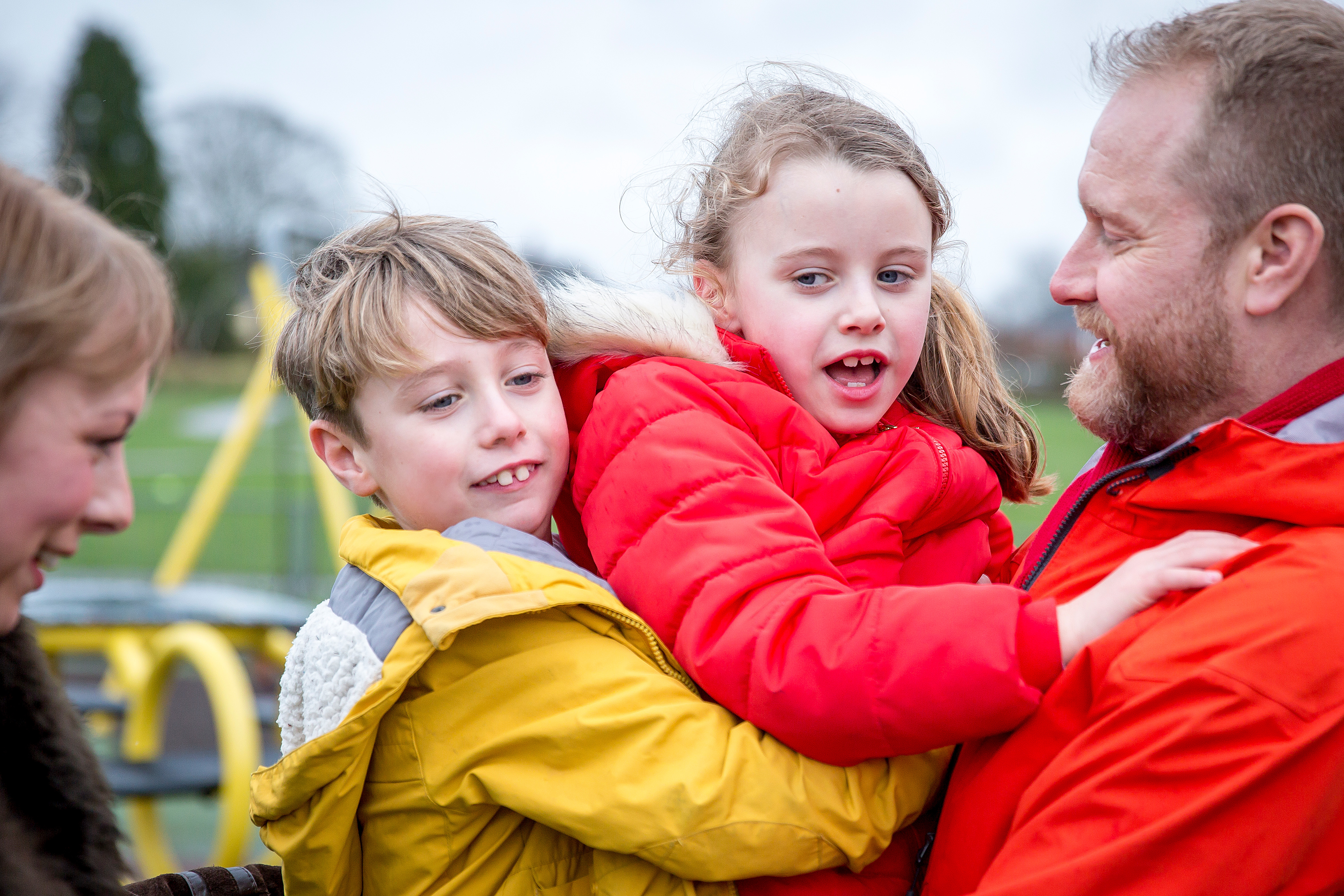 Family hugging in play area
